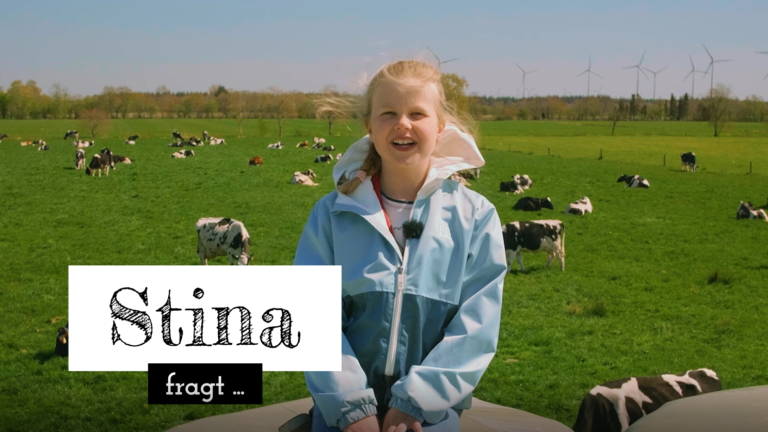 Stina sitzt auf Heuballen