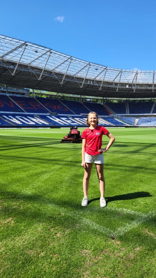 Marie im Stadion von Hannover 96 vor einem Rasenmäher