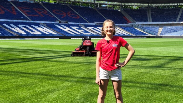 Marie im Stadion von Hannover 96 vor einem Rasenmäher